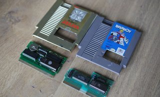 Two NES cartridges with holes cut in them and their pcb boards visible