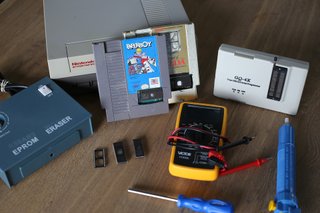 Picture of a nintendo, Paperboy NES game, some chips, screwdrivers and tools